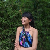Cheryl Hsu outdoors among green leaves, smiling