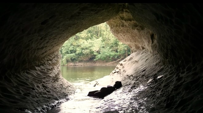 Looking out of a cave onto a river, at the residency
