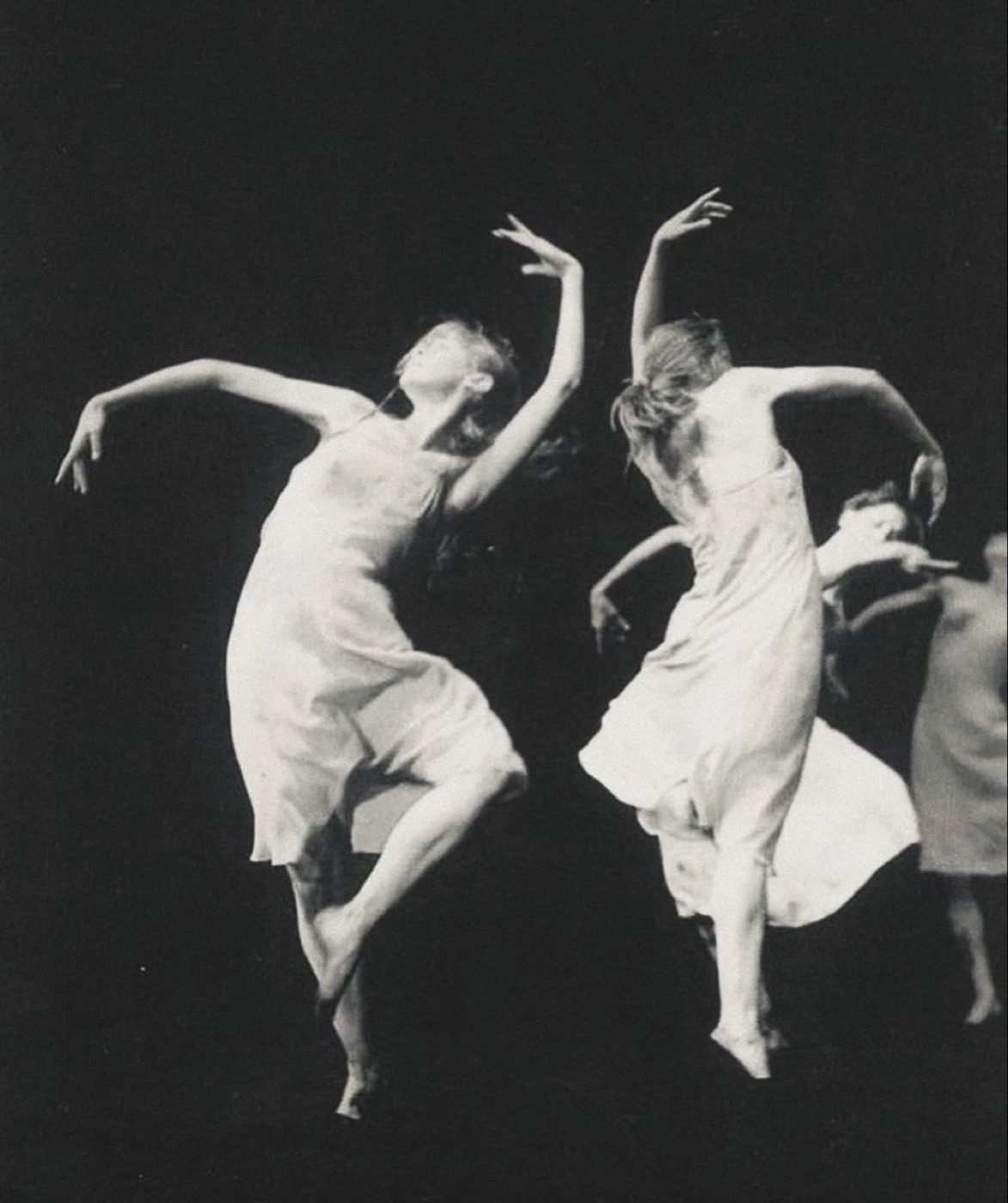 Two dancers with their arms raised